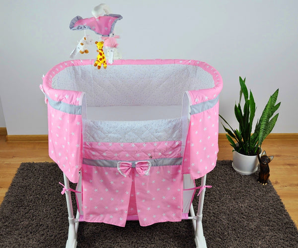 Kuvassa on Milly Mally Cradle Sweet Melody 4-in-1 -sänky, jossa on kaukosäädin ja tähtikuvioita.