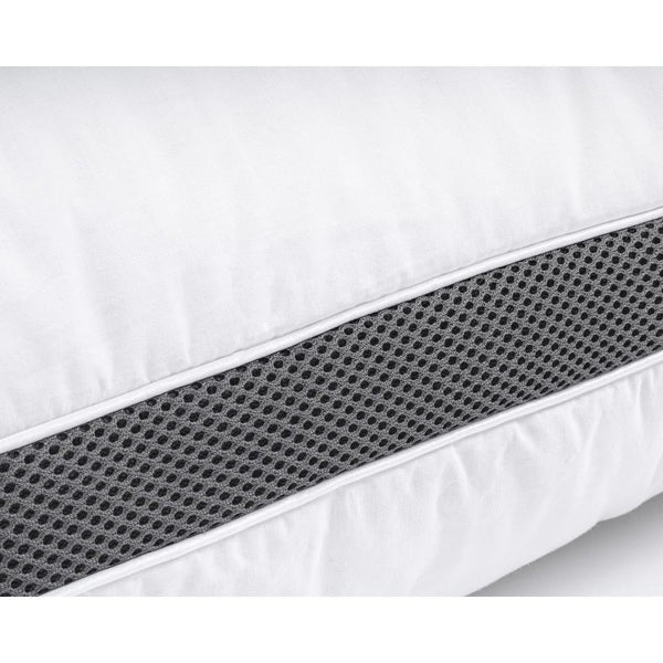 Kuva kolmikammiomaisesta 3D-memory foam -tyynystä vuodevaatteiden päällä.